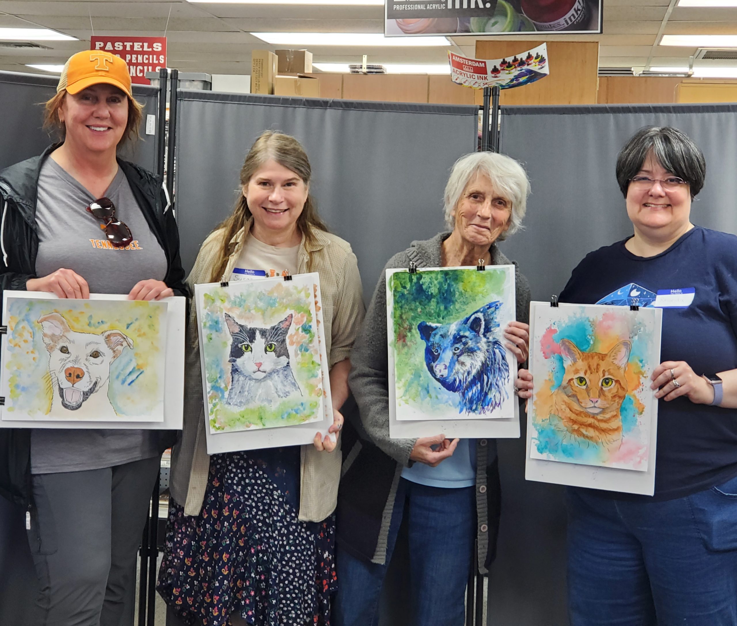 Students showing completed work from paint your pet class
